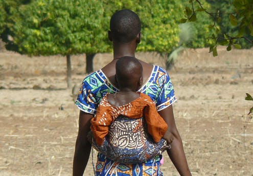 Une jeune maman et son bébé sur le chemin de      l’église