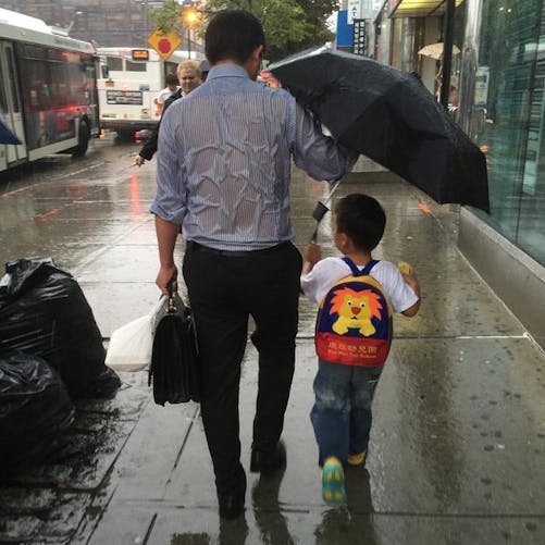 La photo d’un papa, tenant un parapluie pour protéger son
  fils, fait le buzz