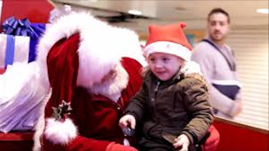 Un père Noël communique avec la langue des signes avec        une petite fille