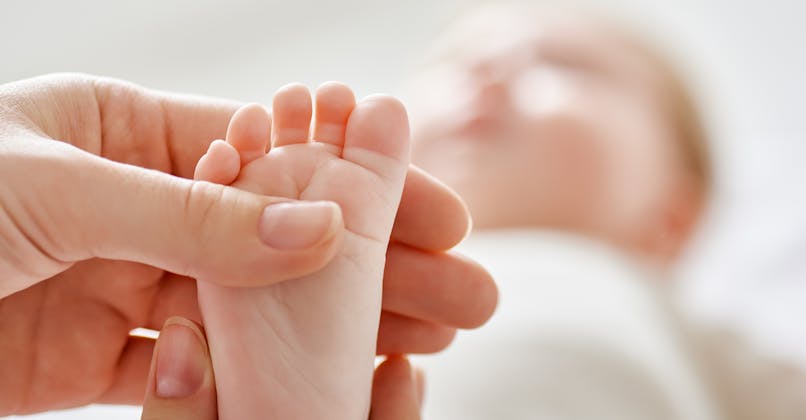 pied de bebe dans une main adulte