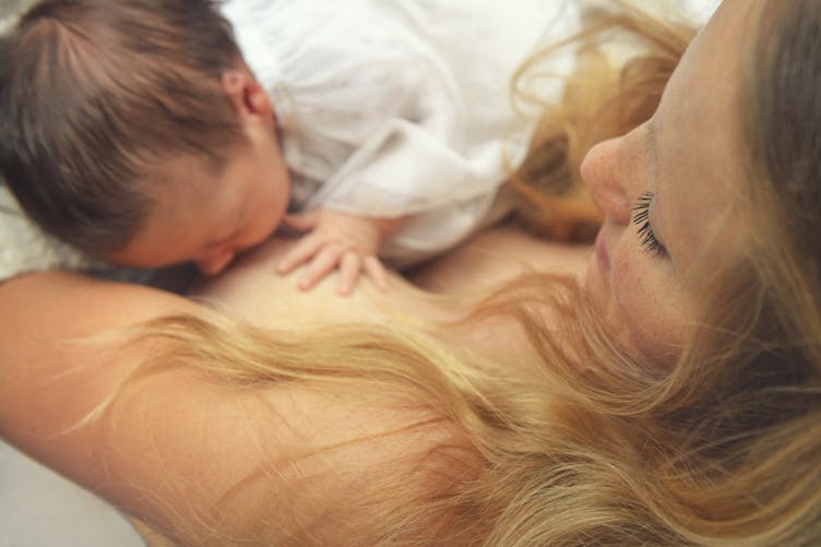 un bébé tète le sein de sa mère