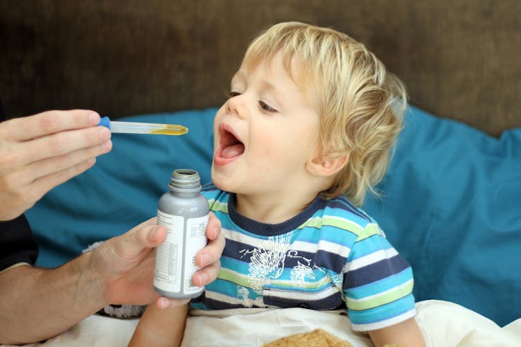 enfant prenant un antibiotique à la pipette