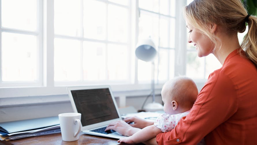 femme travaille ordinateur bébé sur genoux