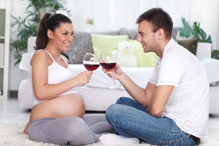 femme enceinte et son compagnon buvant du vin