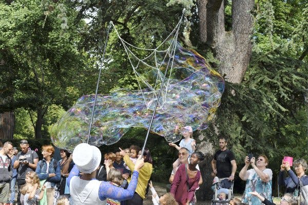 Un artiste fait de grosses bulles en plein air