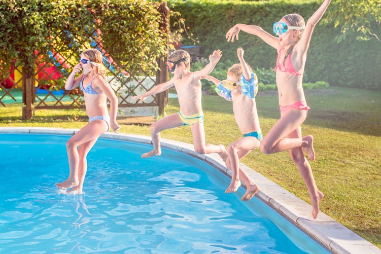 4 enfants sautant dans une piscine privée