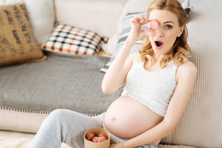 Femme enceinte mangeant des macarons