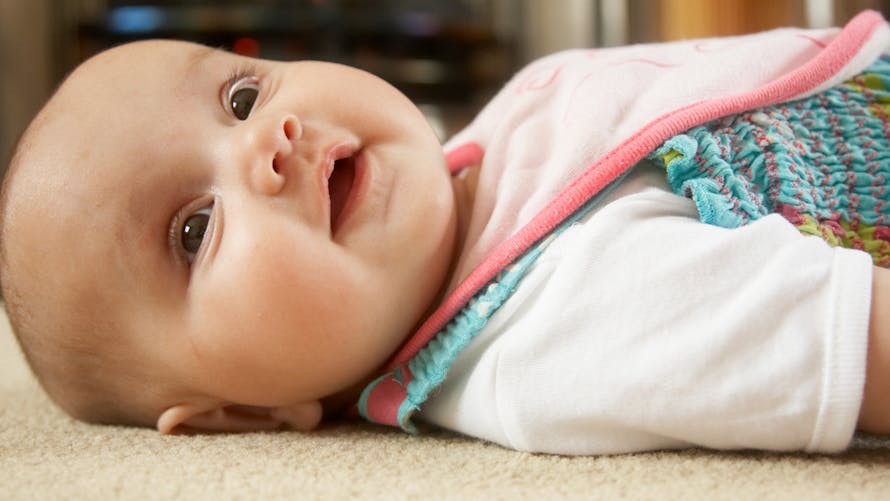 bébé allongé sur un tapis