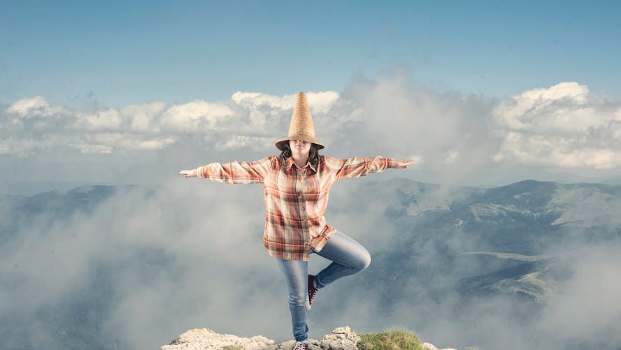 adolescente en équilibre au bord d'une montagne
