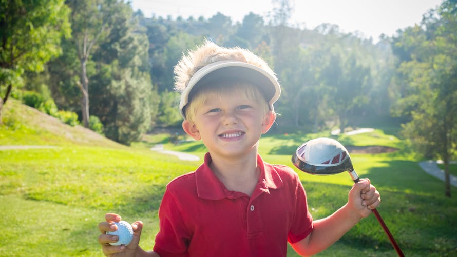 petit garçon jouant au golf