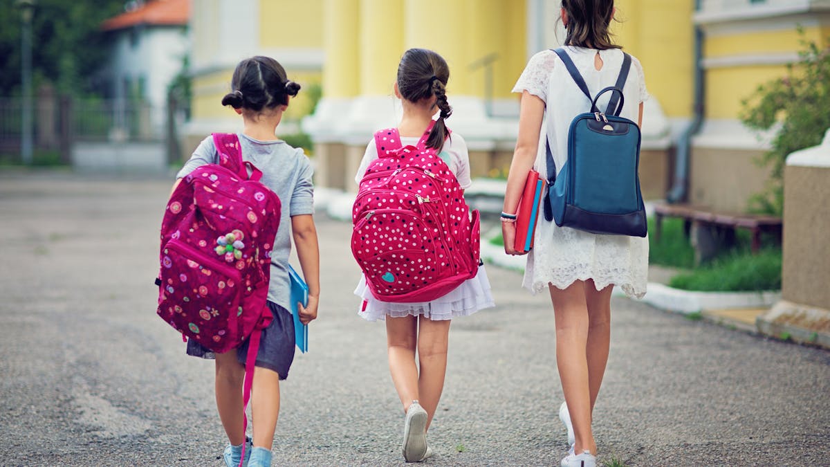 3 fillettes de dos sur le chemin de l'école