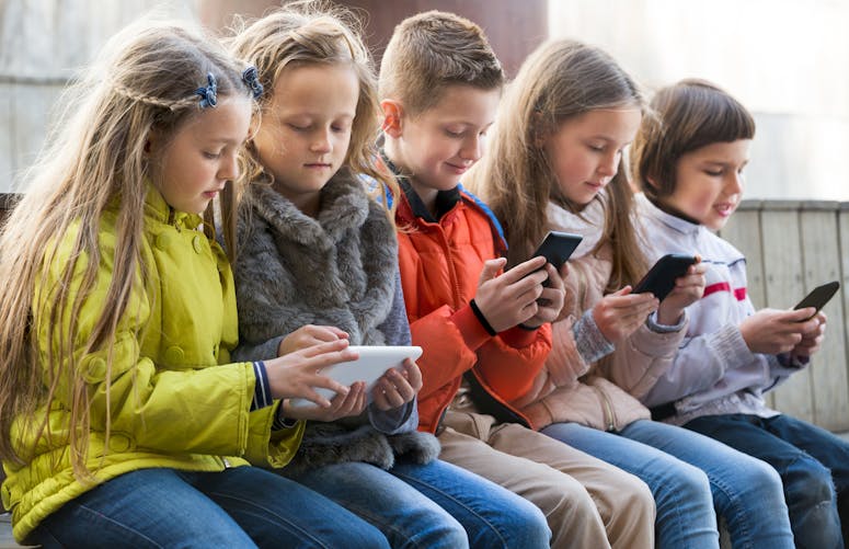 enfants jouant sur tablette et teléphone portable