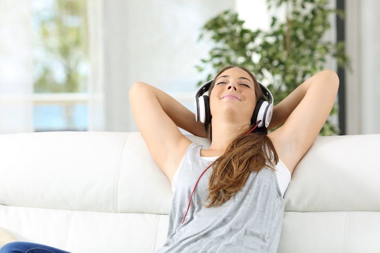 femme se relaxant avec des écouteurs sur les oreilles