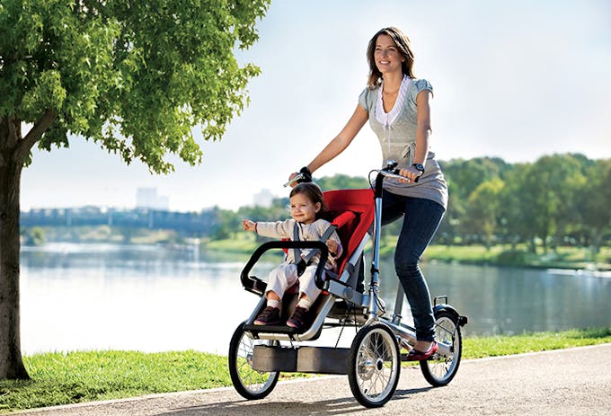 Maman qui se promène au parc avec bébé en vélo Taga.