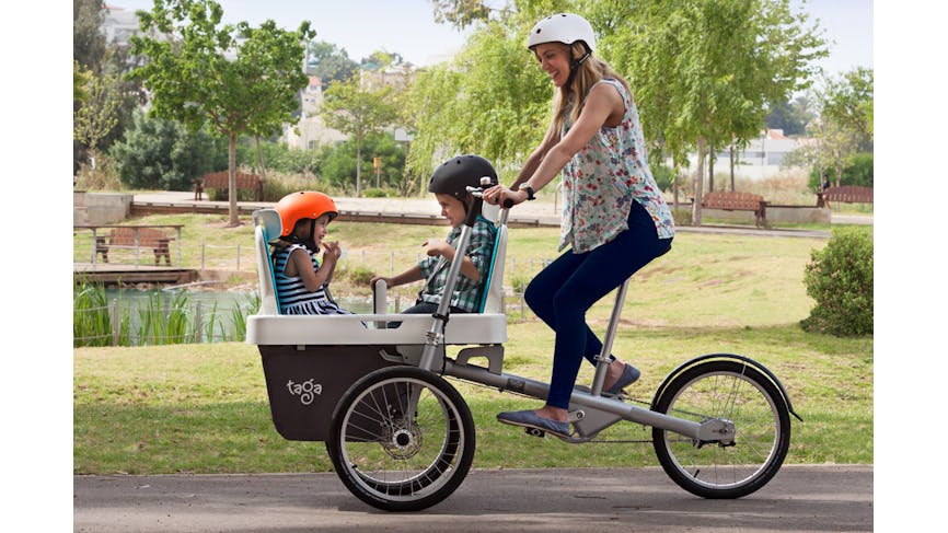 Maman qui pédale son vélo Taga avec deux enfants.