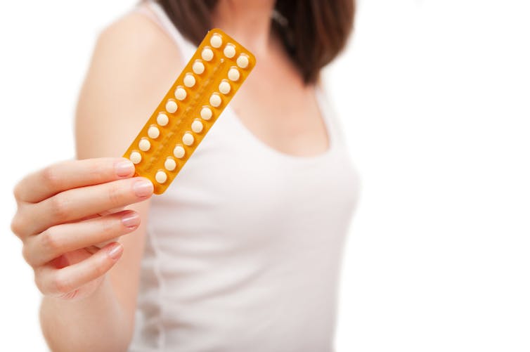 femme tenant une plaquette de pilule