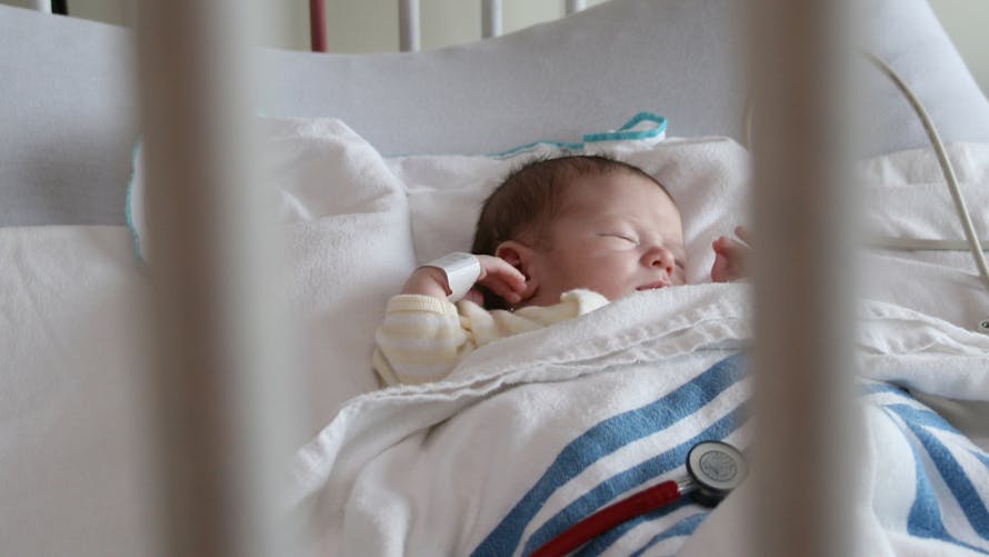 bébé dans un lit d'hôpital