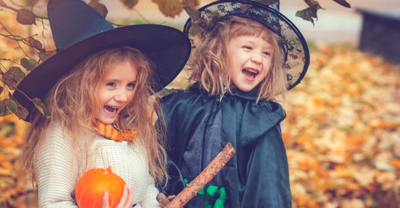enfants déguisés Halloween sur un tapis de feuilles d'automne