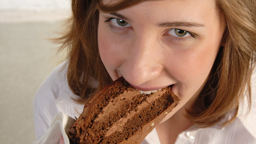 adolescente mangeant un gâteau au chocolat