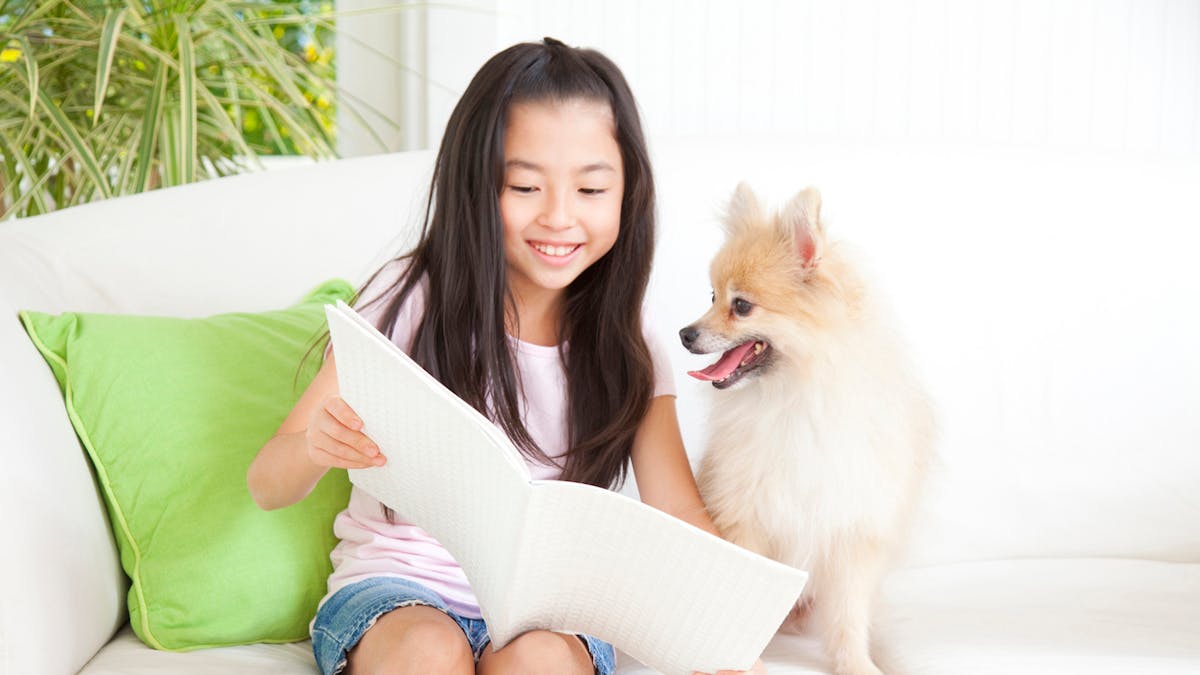 petite fille lisant et son chien