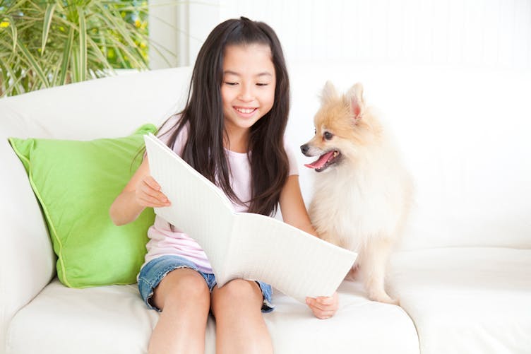 petite fille lisant et son chien