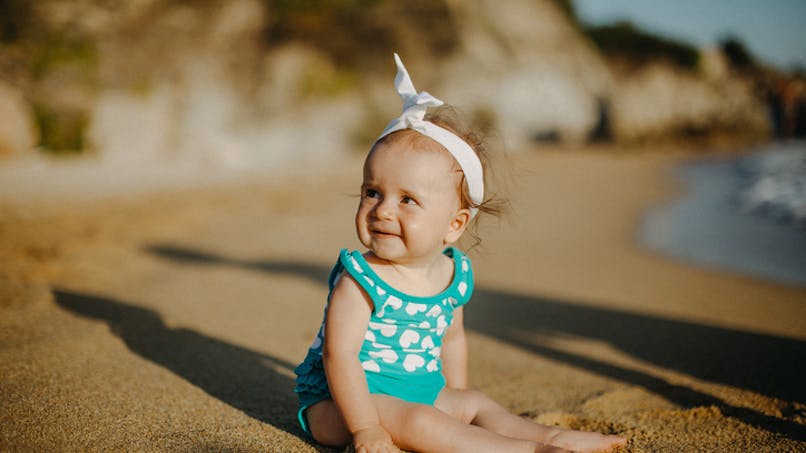 une petite fille souriante sur une plage