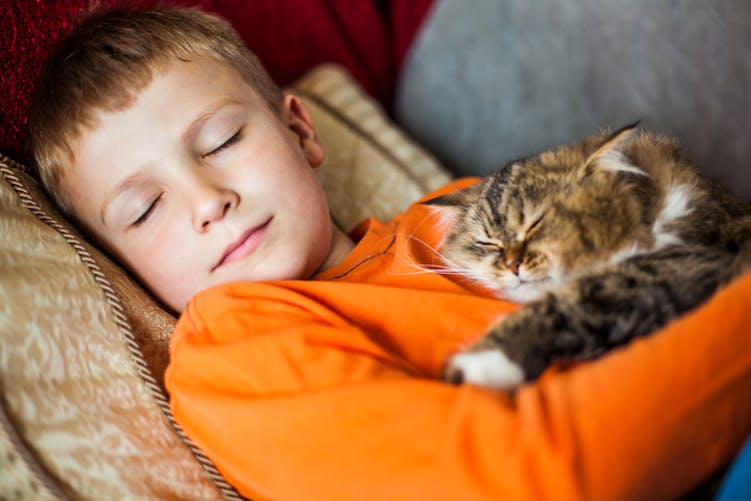 Un garçon dormant avec un chat