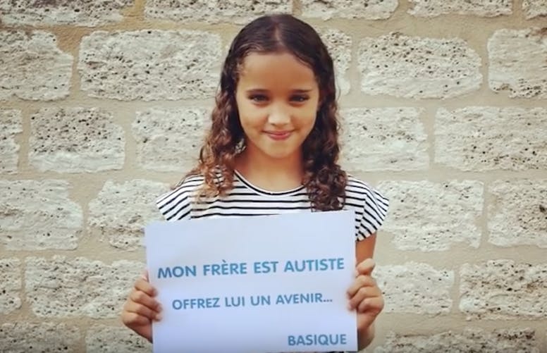 petite fille tient un panneau sur l'autisme