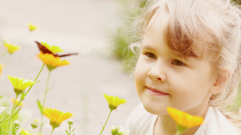 une petite fille parmi des fleurs