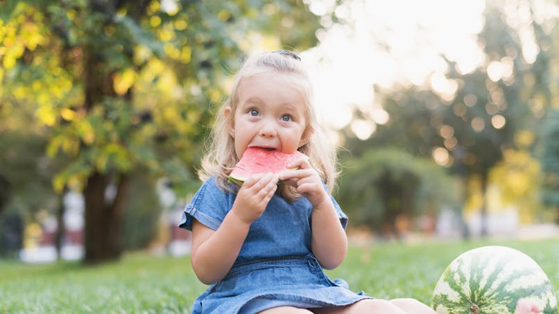 une enfant qui mange de la pastèque