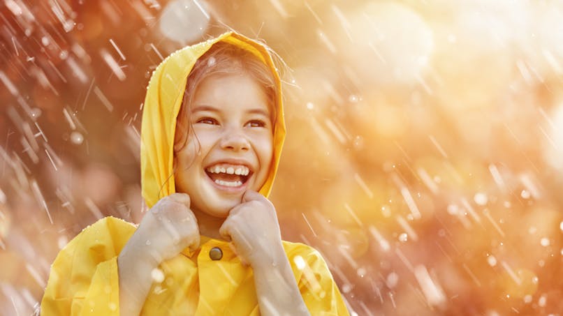 une enfant avec parka sous une pluie