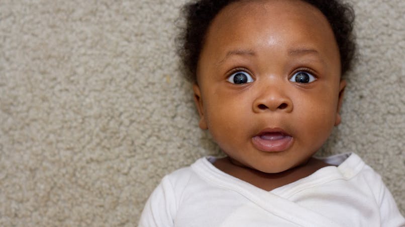 un bébé qui ouvre de grands yeux surpris