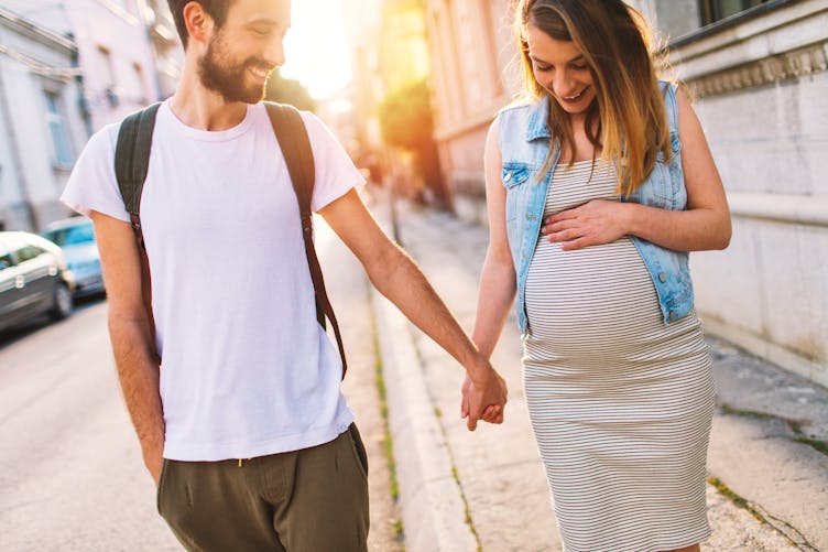 un homme et une femme enceinte dans la rue