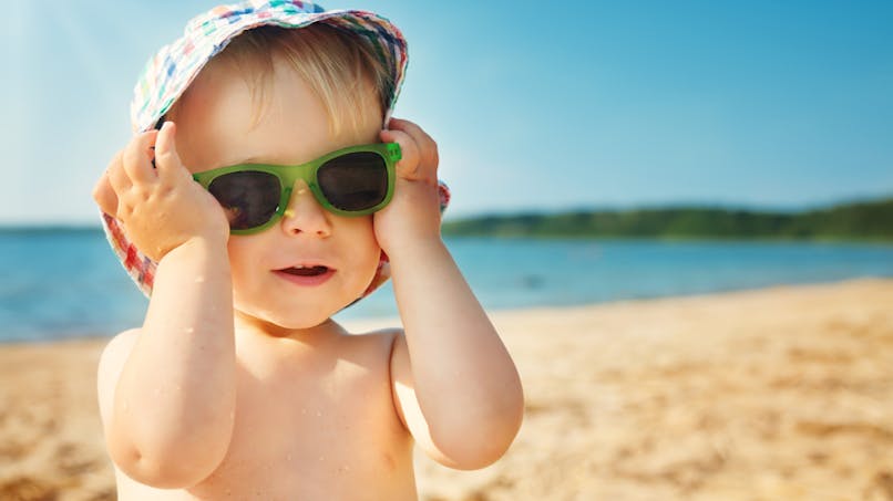 petite fille qui porte des lunettes de soleil, sur la plage