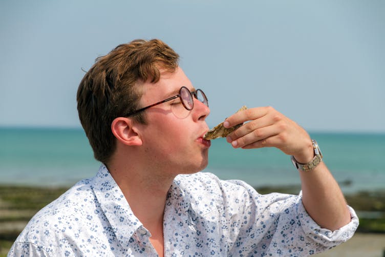 homme mangeant une huître