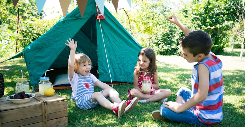enfants jouent devant une tente