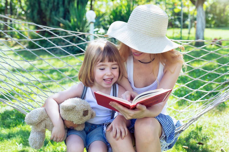 maman et fillette lisant dans un hamac