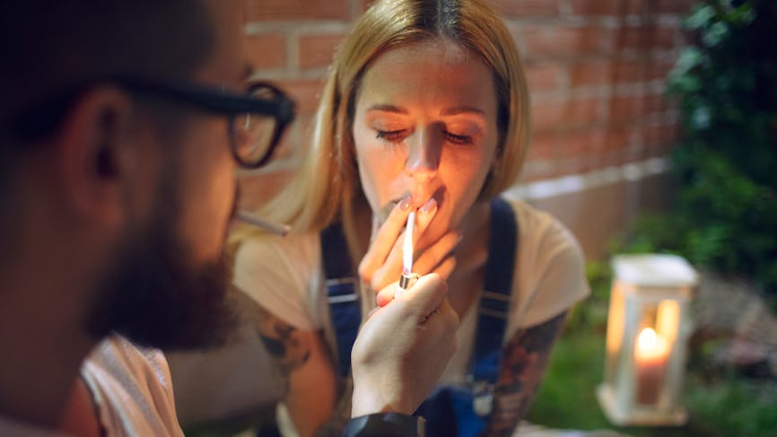 Couple fumant une cigarette de cannabis