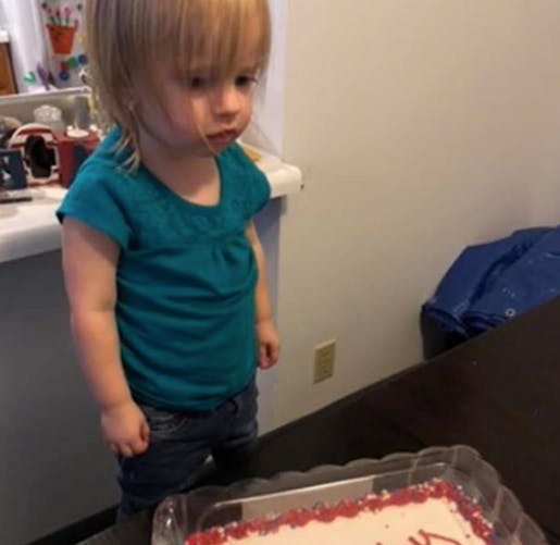 fillette devant son gâteau d'anniversaire
