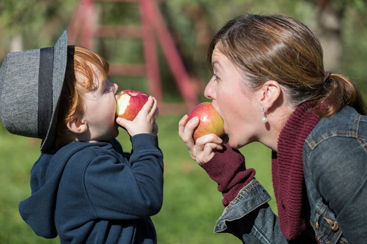 enfant et maman mangeant une pomme