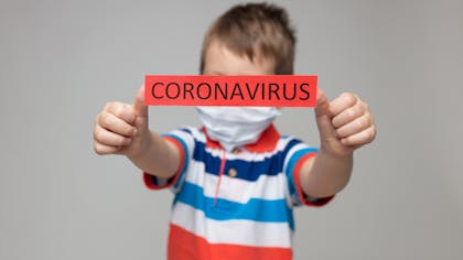 enfant avec un message Coronavirus