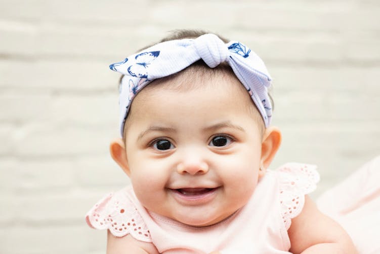 bébé souriant avec noeud dans cheveux