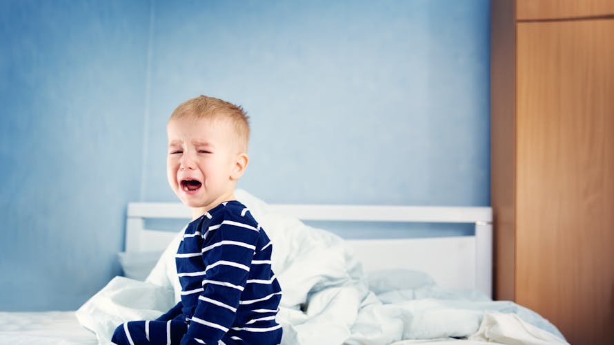 enfant pleurant dans son lit