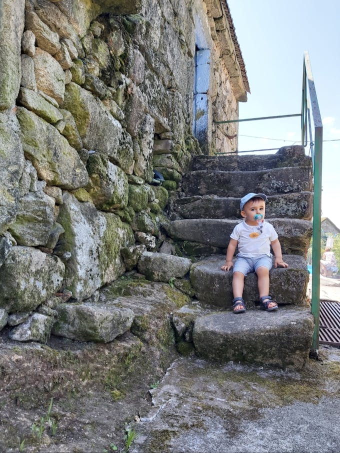 bébé au pied d'un escalier en pierre