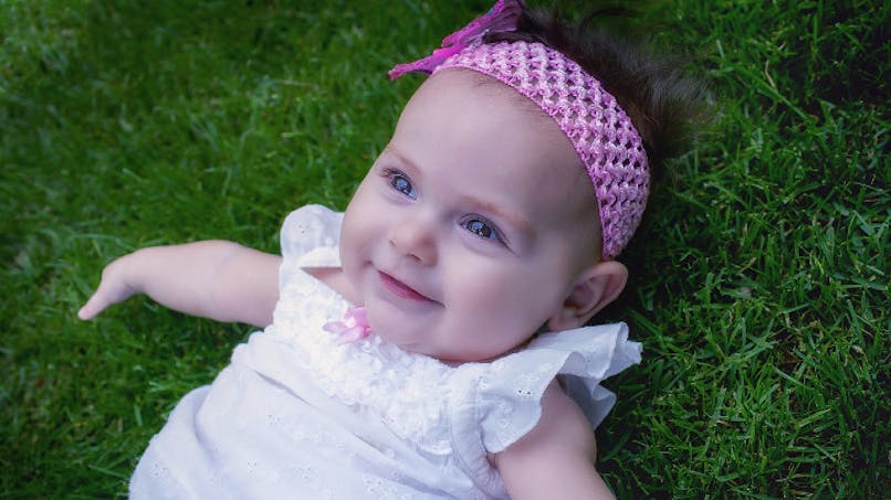 bébé avec bandeau rose dans les cheveux