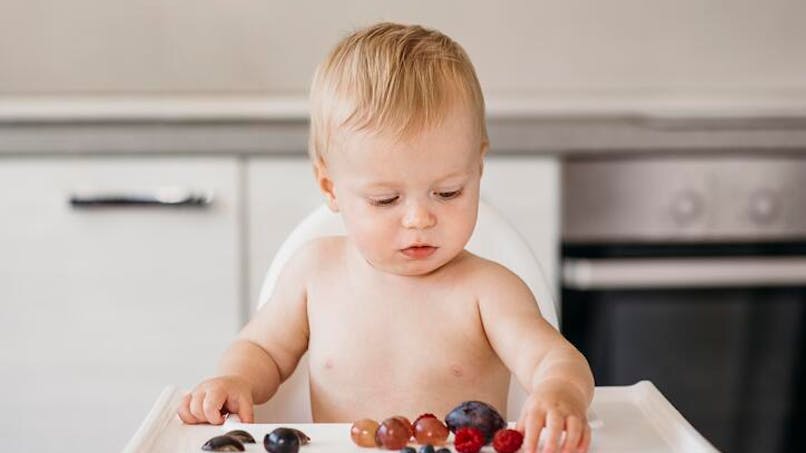 bébé manipule des fruits