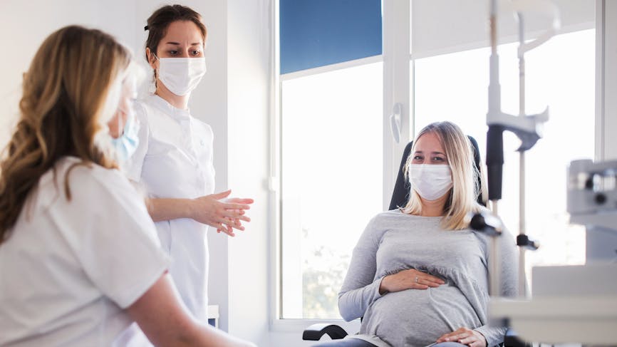 Une femme enceinte est auscultée par des médecins.