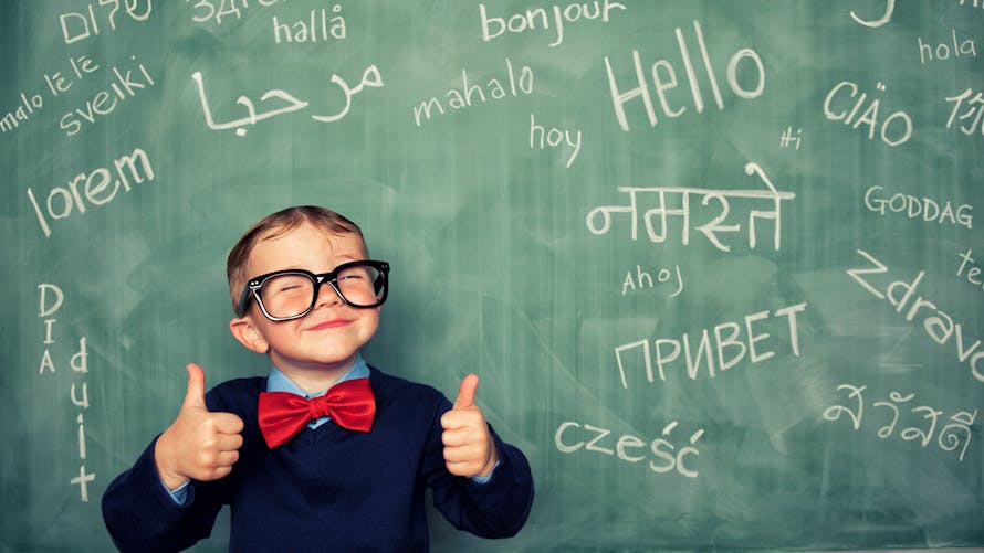 enfant devant tableau écrit Hello dans toutes les langues