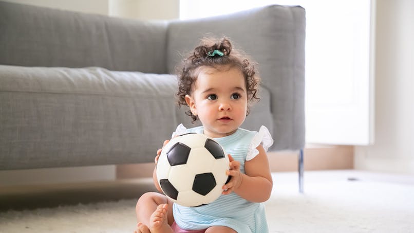 bébé dans le salon tenant un ballon