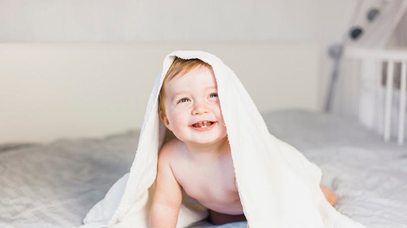 bébé souriant sous une serviette